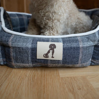 AllPetSolutions Alfie check dog bed with a dog resting inside