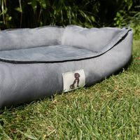 AllPetSolutions Dexter grey waterproof dog bed with a dog lying on it