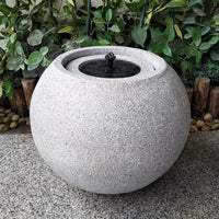 AllPetSolutions light grey round stone fountain running in a garden
